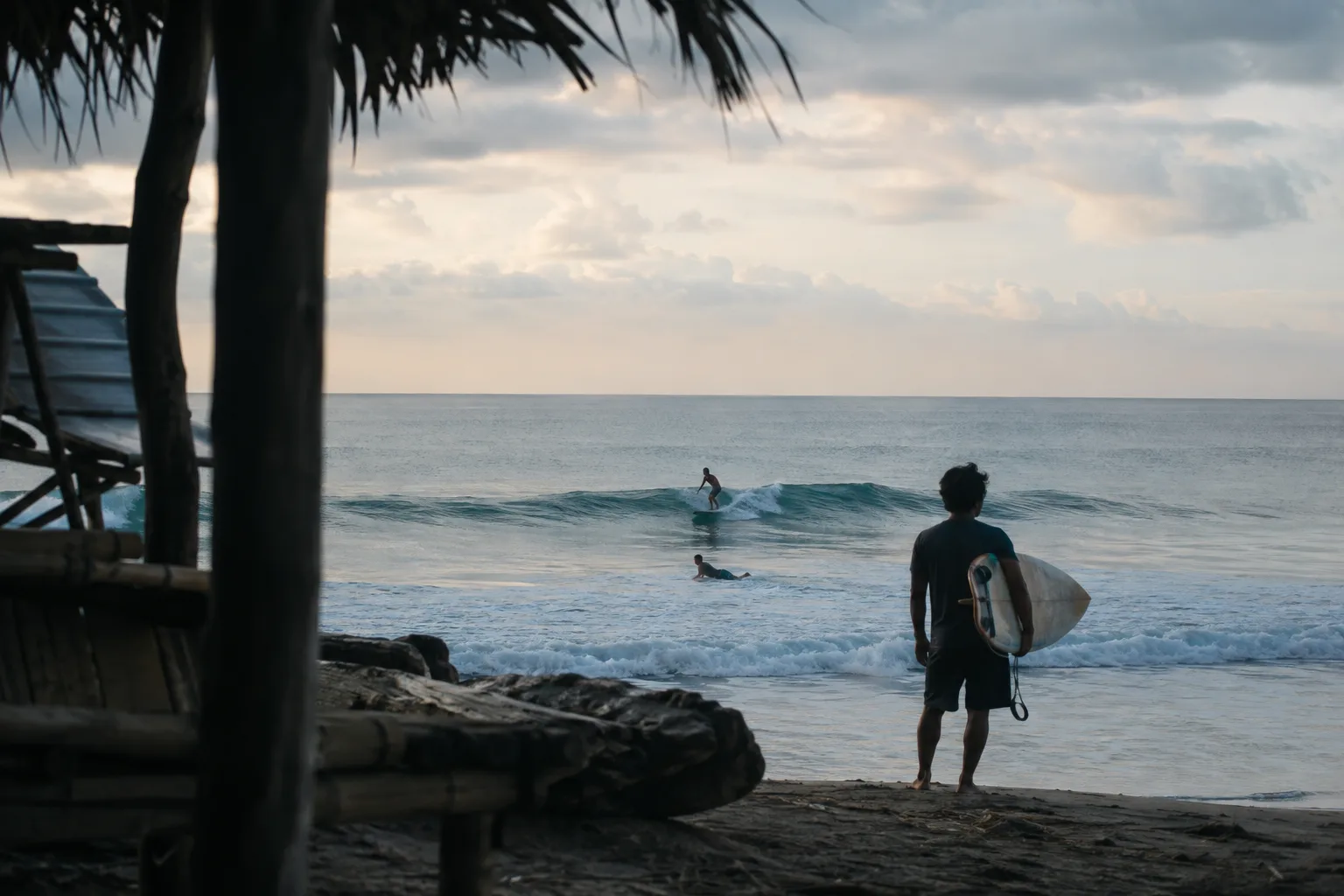 Seorang surfer mengamati lineup yang tenang di Indonesia saat pagi